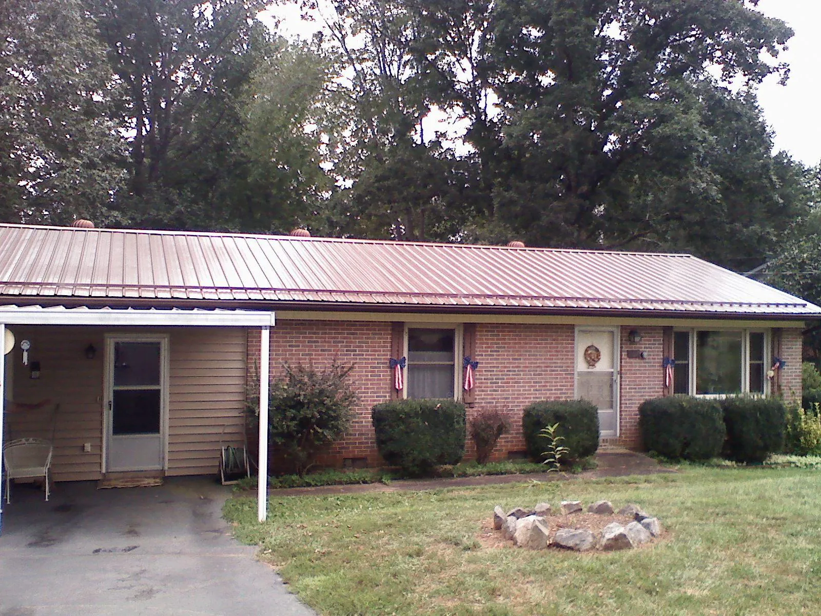 Bronze metal roof and carport on a brick ranch home — Roof Repair work by our crew in Canoga Park